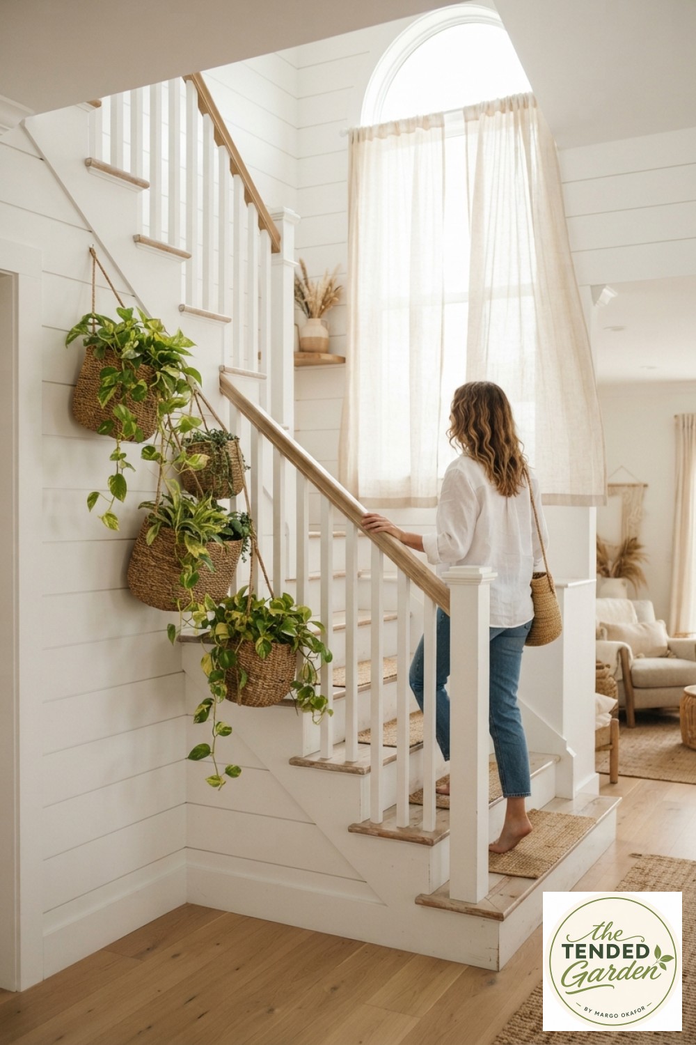 Coastal white staircase with a rattan stair railing plant hanger cluster holding cascading pothos baskets